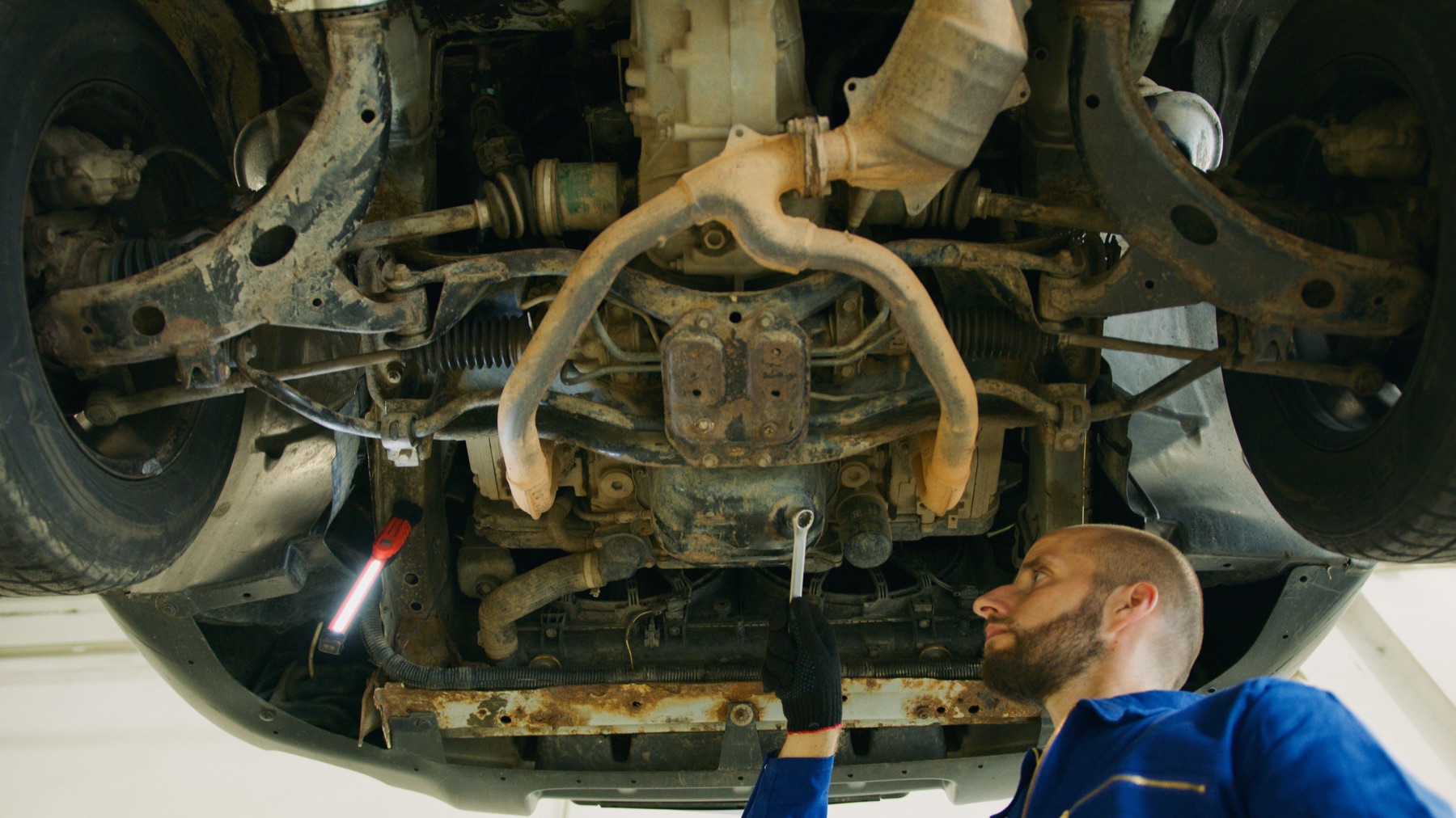Technician inspecting a vehicle in a clean automotive service bay